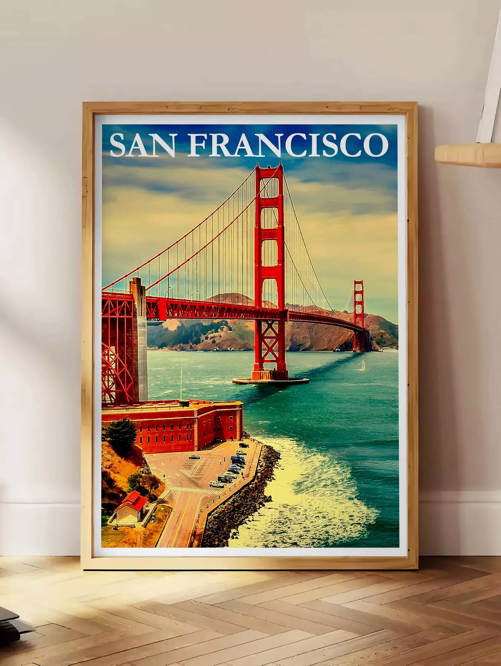 Estampe affiche San Francisco vintage, posee au sol dans un coin salon, sur un parquet a chevrons, pres d'une table d'appoint en chene chargee de livres