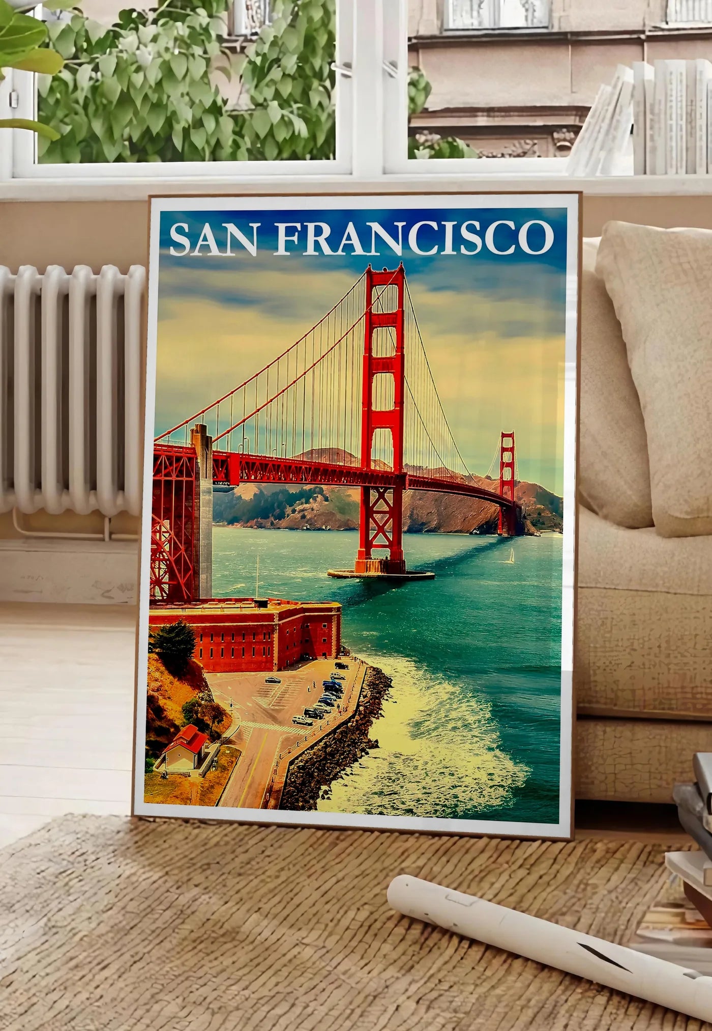 Poster affiche San Francisco vintage, posee au sol dans un salon parisien, devant une grande fenetre donnant sur un immeuble haussmannien, entre un ficus et un canape creme