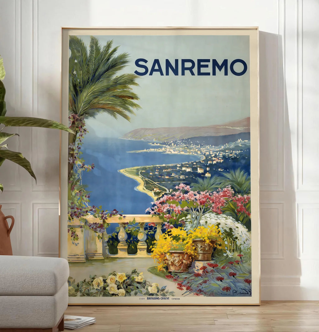 Reproduction affiche Sanremo vintage, posee au sol dans un salon minimaliste clair, a cote d'un canape beige et d'une plante verte, sur un parquet clair