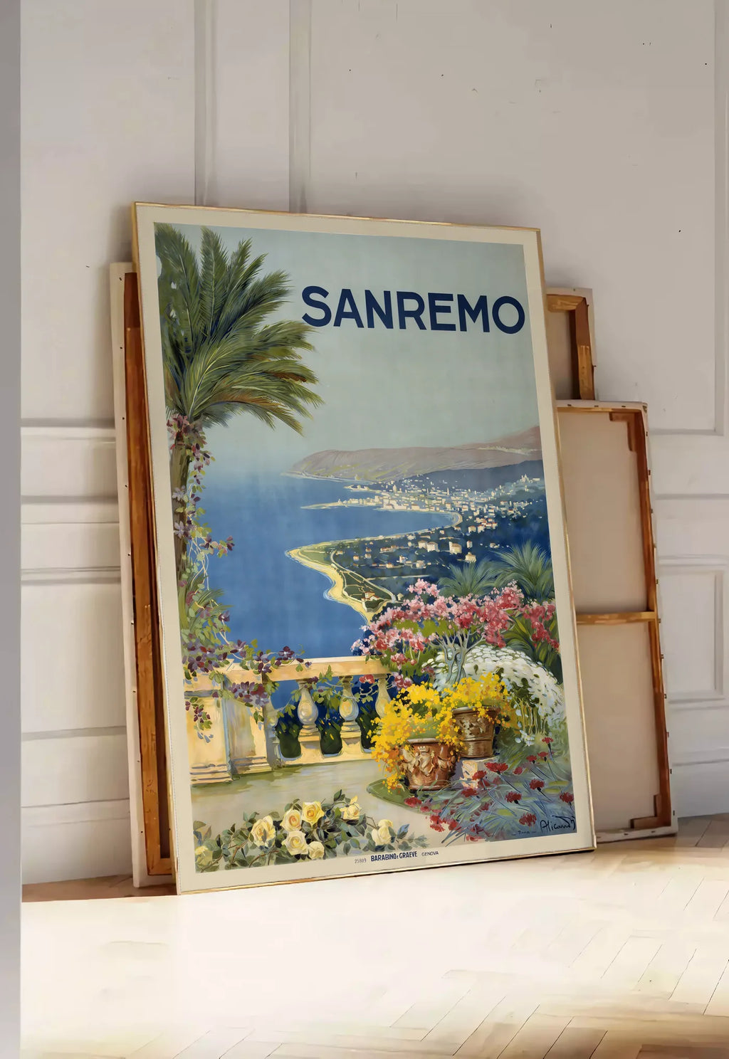 Tirage encadrable affiche Sanremo vintage, posee au sol dans une entree lumineuse, contre un mur a panneaux blancs, a cote de chassis en bois empiles