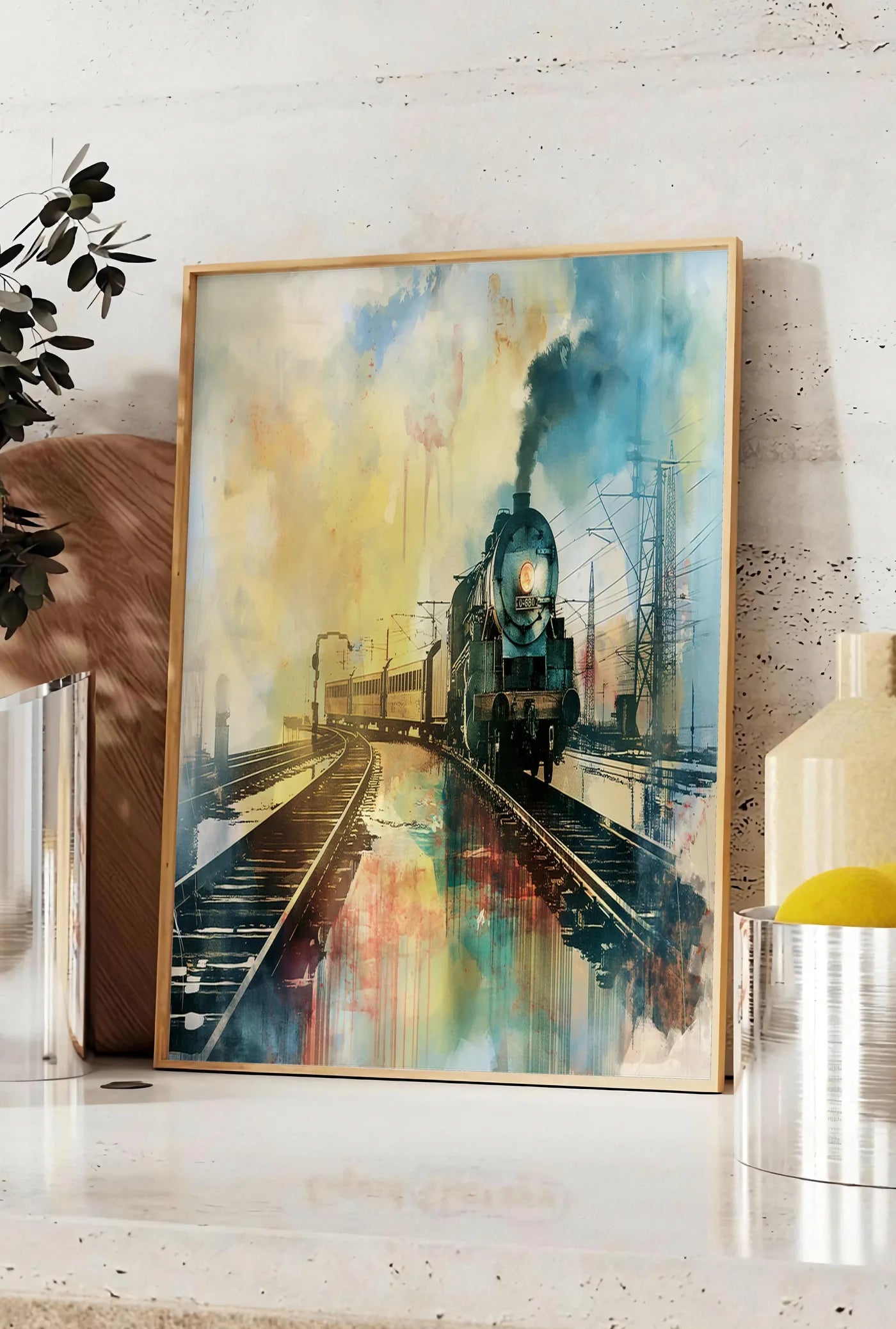 Affiche affiche train vapeur vintage, posee sur un plan de travail de cuisine en pierre claire, entre une branche d'eucalyptus en vase et un bocal de citrons