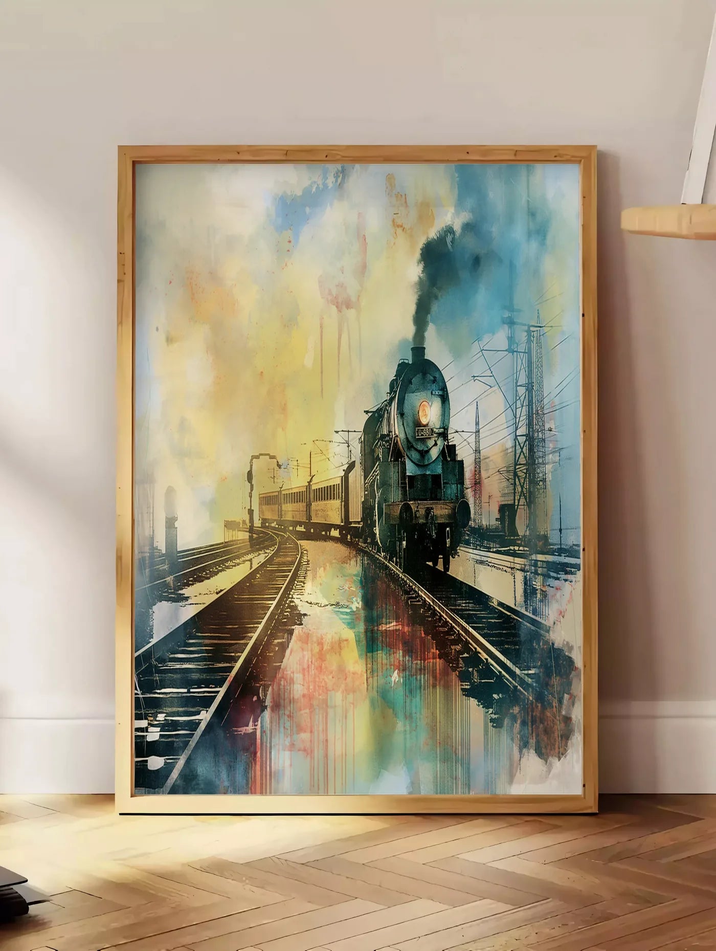 Estampe affiche train vapeur vintage, posee au sol dans un coin salon, sur un parquet a chevrons, pres d'une table d'appoint en chene chargee de livres