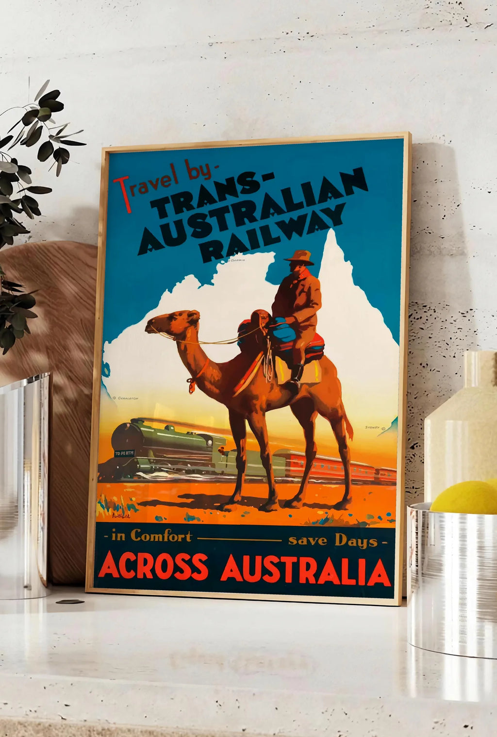 Affiche affiche Australie vintage, posee sur un plan de travail de cuisine en pierre claire, entre une branche d'eucalyptus en vase et un bocal de citrons