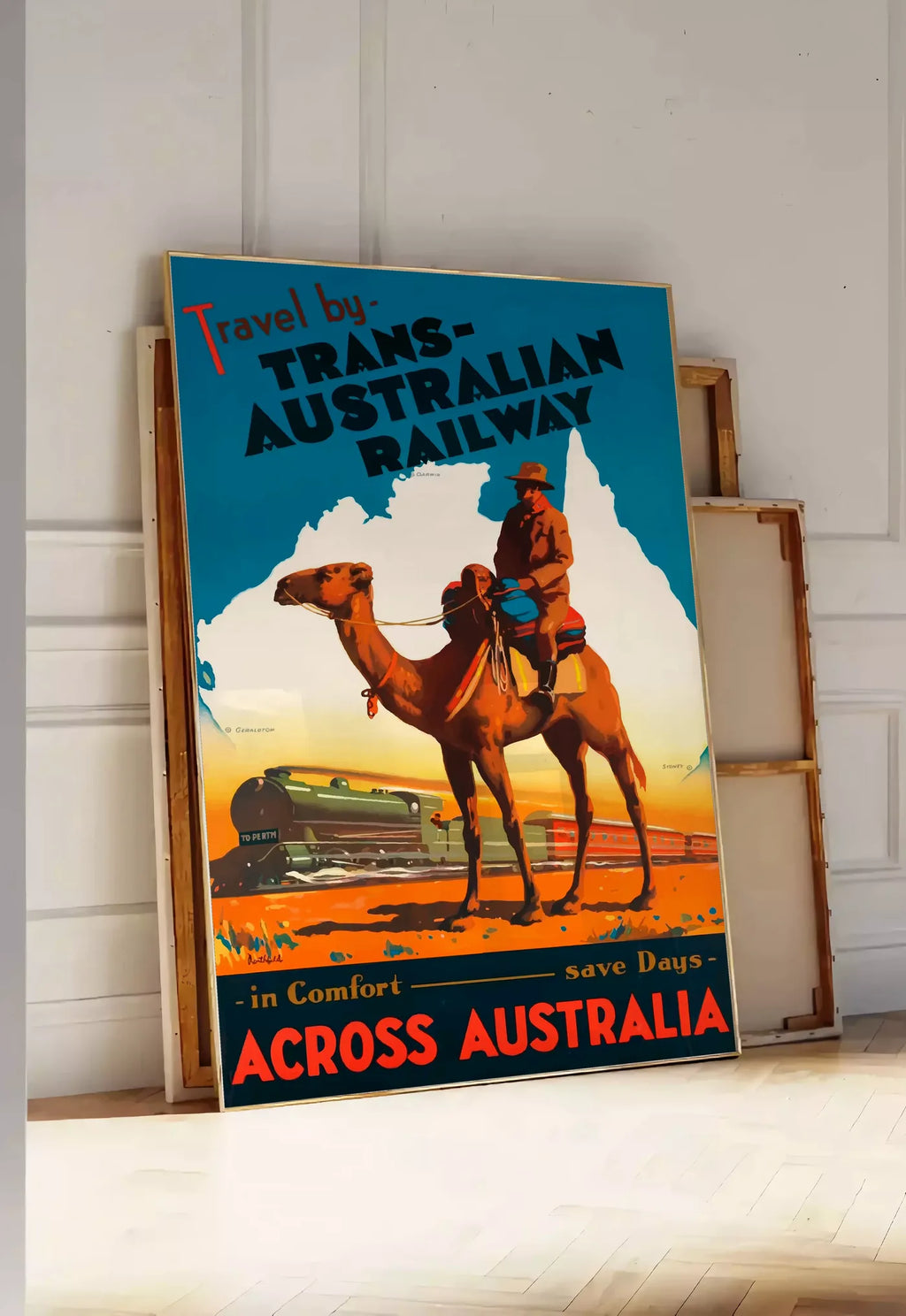 Tirage encadrable affiche Australie vintage, posee au sol dans une entree lumineuse, contre un mur a panneaux blancs, a cote de chassis en bois empiles