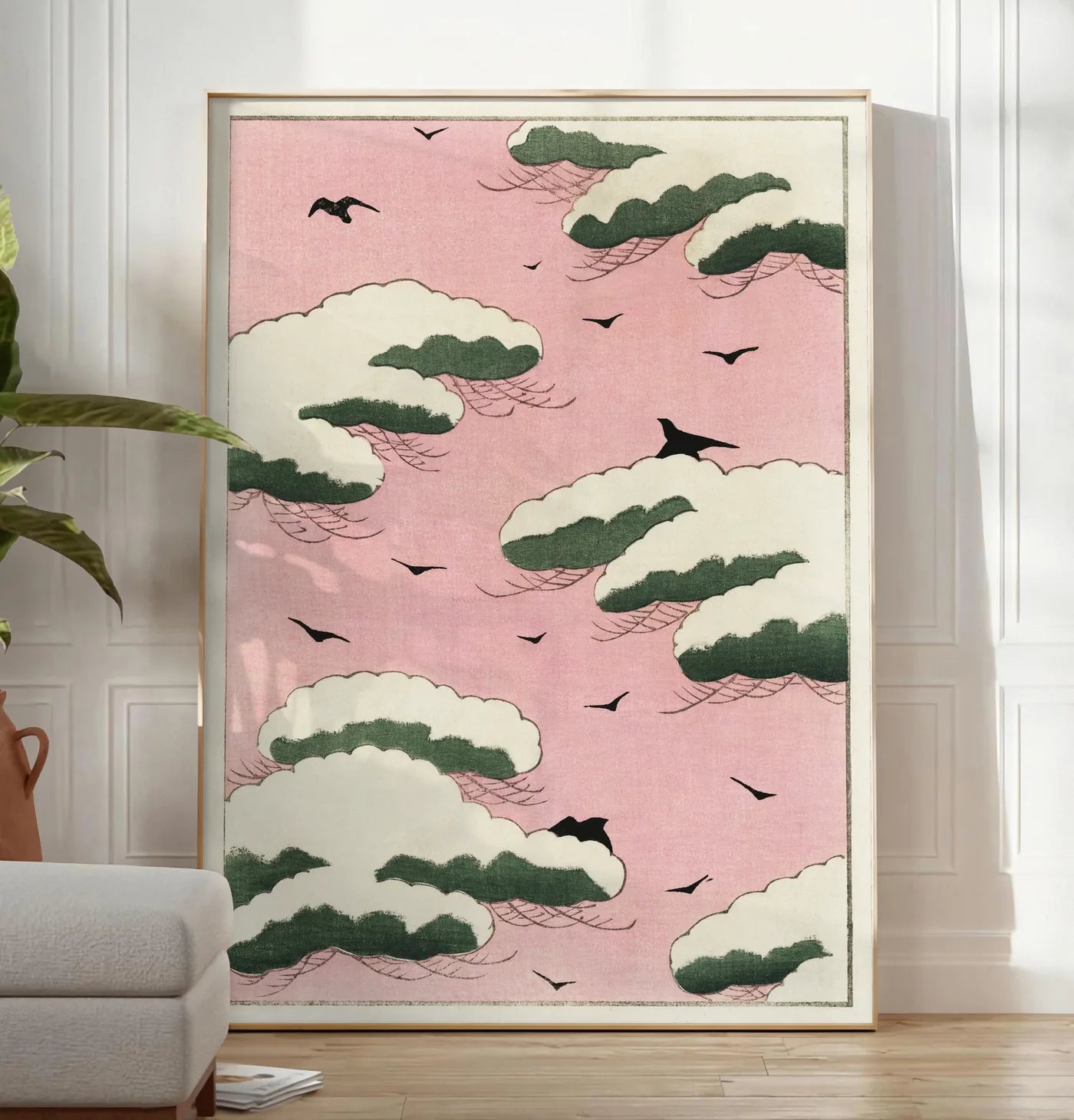 Reproduction affiche nuages verts et oiseaux sur ciel rose de Watanabe Seitei estampe japonaise, posee au sol dans un salon minimaliste clair, a cote d'un canape beige et d'une plante verte, sur un parquet clair