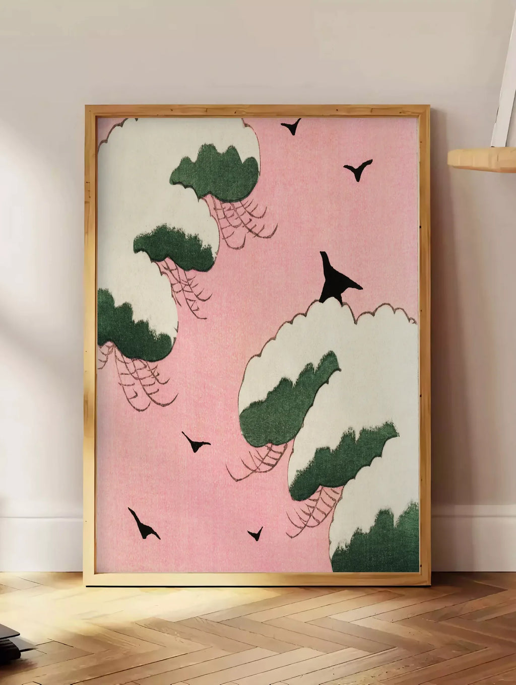 Estampe affiche oiseaux et nuages de Seitei art japonais, posee au sol dans un coin salon, sur un parquet a chevrons, pres d'une table d'appoint en chene chargee de livres