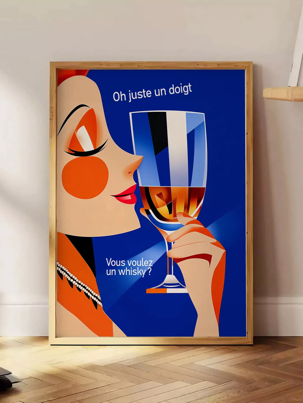 Estampe affiche cocktail whisky art deco, posee au sol dans un coin salon, sur un parquet a chevrons, pres d'une table d'appoint en chene chargee de livres