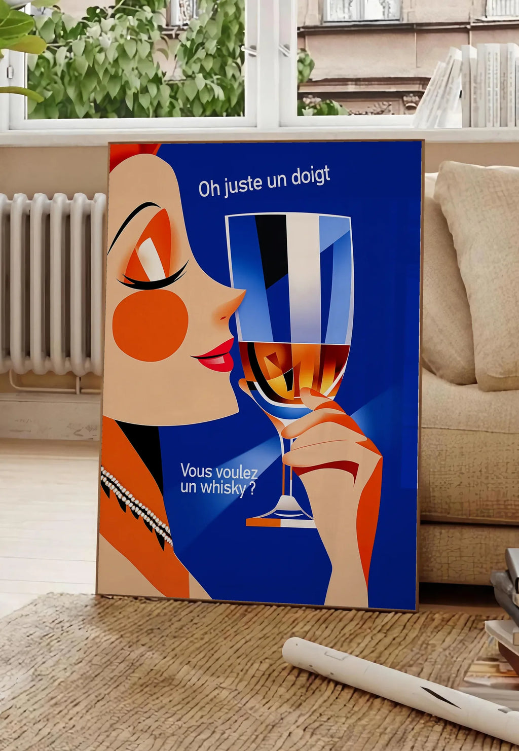 Poster affiche cocktail whisky art deco, posee au sol dans un salon parisien, devant une grande fenetre donnant sur un immeuble haussmannien, entre un ficus et un canape creme