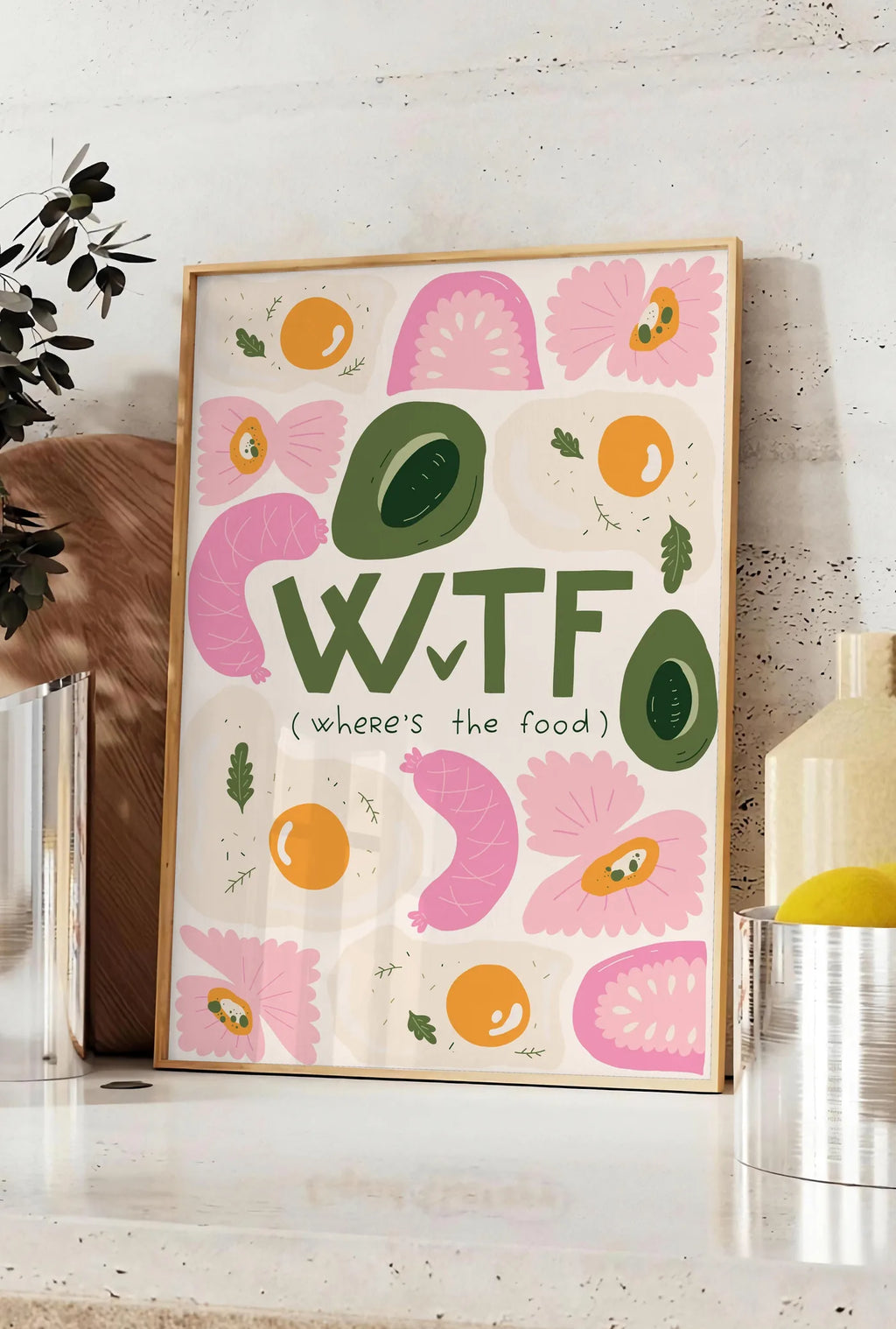Affiche affiche cuisine food WTF, posee sur un plan de travail de cuisine en pierre claire, entre une branche d'eucalyptus en vase et un bocal de citrons