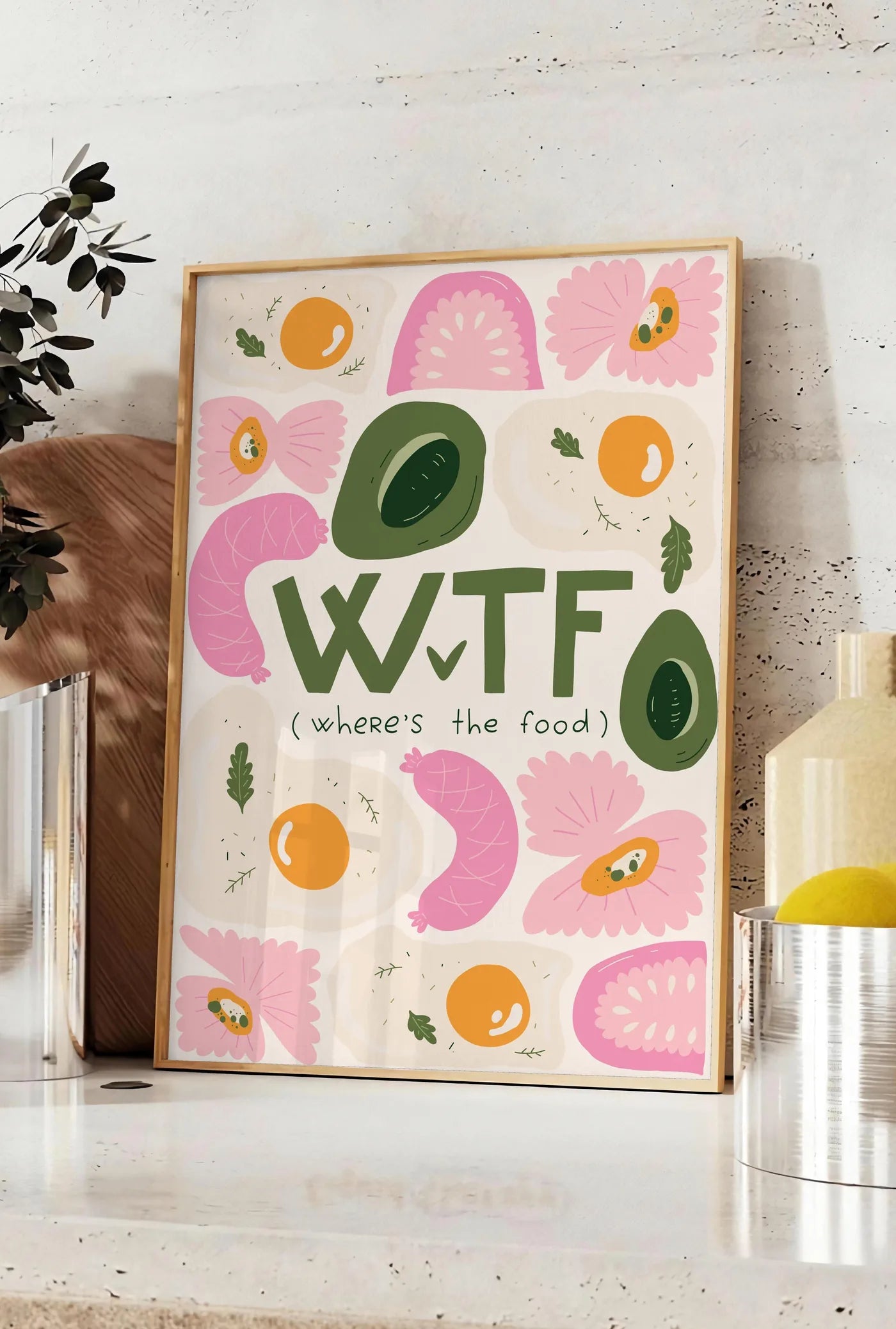 Affiche affiche cuisine food WTF, posee sur un plan de travail de cuisine en pierre claire, entre une branche d'eucalyptus en vase et un bocal de citrons
