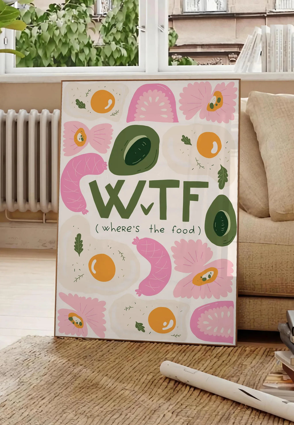 Poster affiche cuisine food WTF, posee au sol dans un salon parisien, devant une grande fenetre donnant sur un immeuble haussmannien, entre un ficus et un canape creme